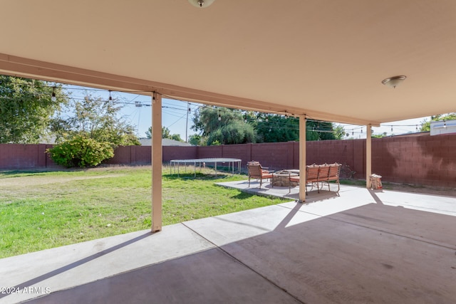 view of patio with a trampoline and a fenced backyard