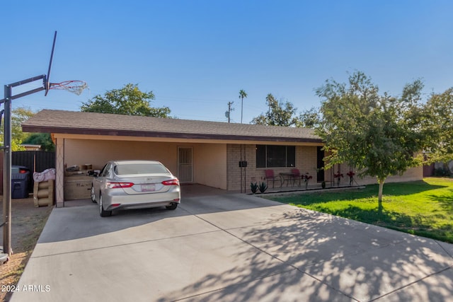 single story home featuring a garage, a front yard, concrete driveway, and brick siding