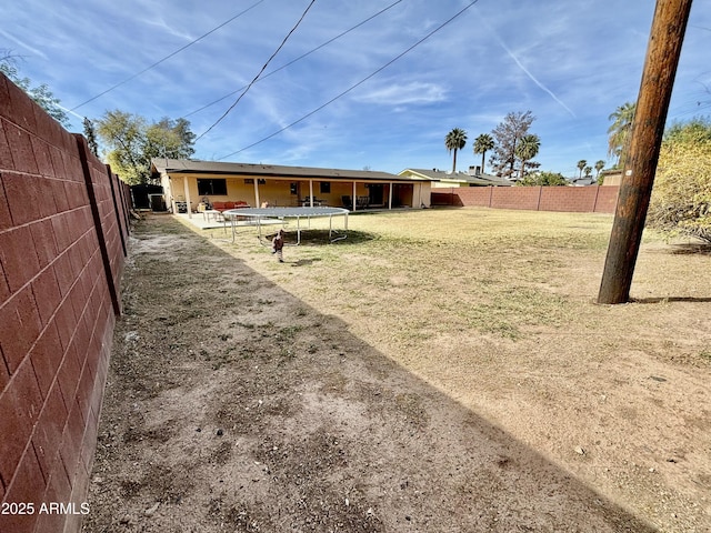 view of yard featuring a fenced backyard and a trampoline