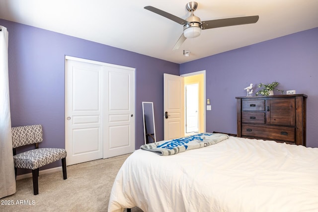 bedroom featuring ceiling fan, light colored carpet, and a closet