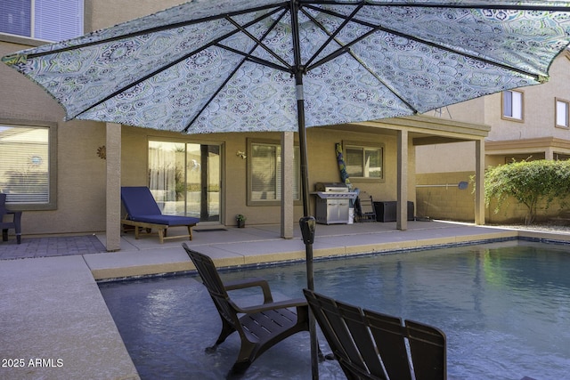 view of pool featuring grilling area and a patio area