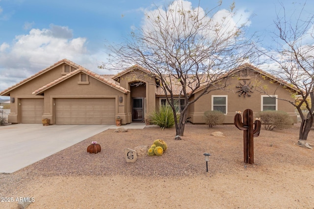 view of front of home featuring an attached garage, driveway, a tiled roof, and stucco siding