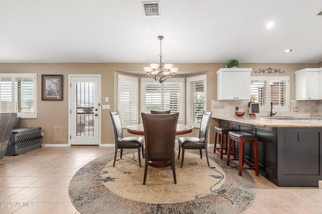 dining space with light tile patterned floors, a chandelier, recessed lighting, visible vents, and baseboards