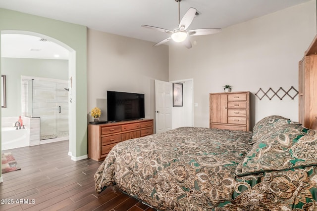 bedroom with arched walkways, ceiling fan, vaulted ceiling, and dark wood finished floors