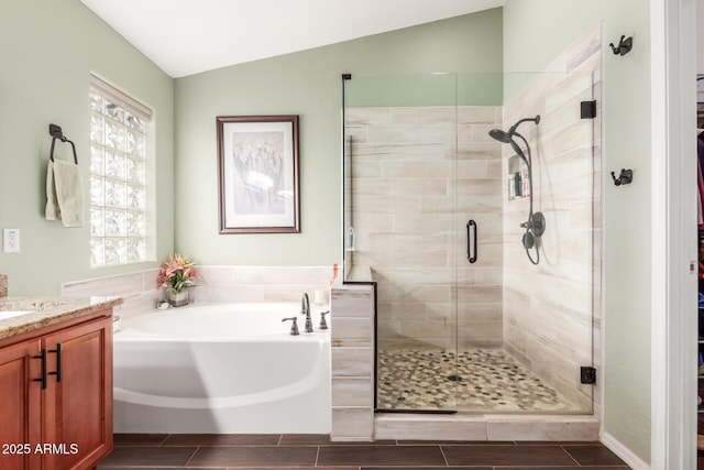 bathroom featuring a shower stall, vaulted ceiling, a bath, and vanity