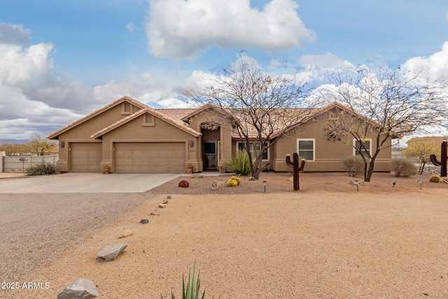 view of front of home featuring driveway, a tiled roof, a garage, and stucco siding