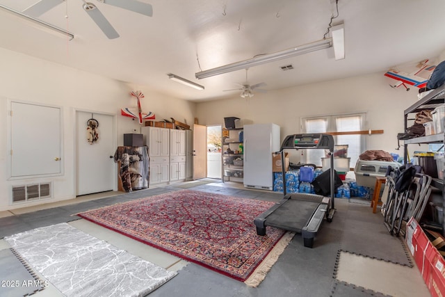 garage featuring visible vents, a ceiling fan, and freestanding refrigerator