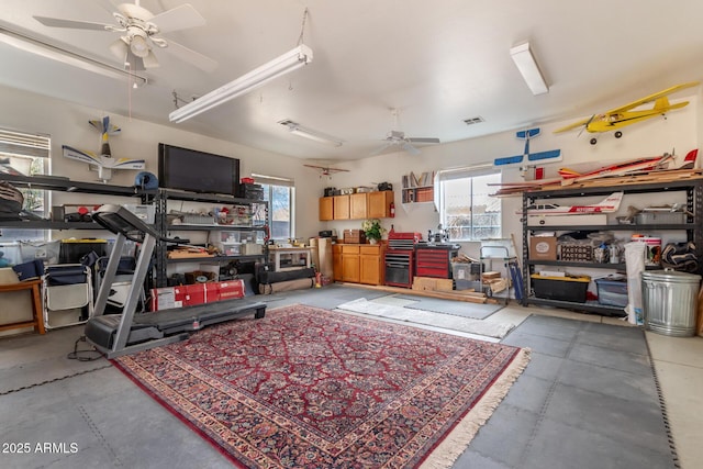 garage featuring ceiling fan, a workshop area, and visible vents