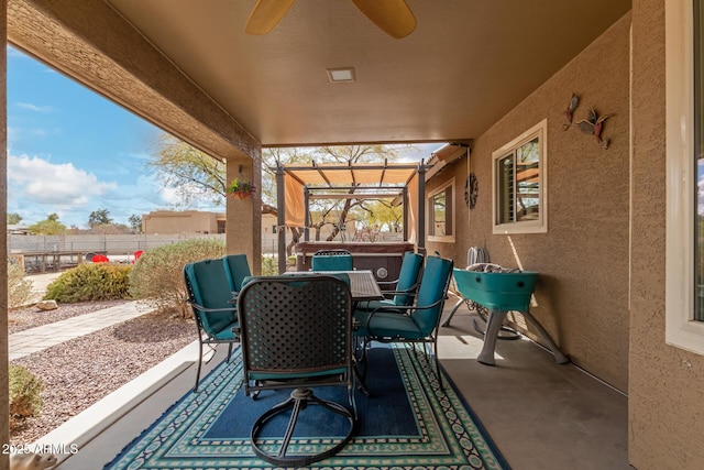 view of patio / terrace with outdoor dining area, fence, a ceiling fan, and a hot tub