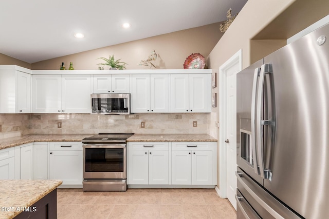 kitchen with white cabinets, tasteful backsplash, vaulted ceiling, and stainless steel appliances