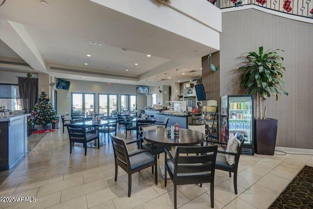 tiled dining area with a raised ceiling