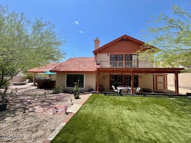 back of property with a patio area and a yard