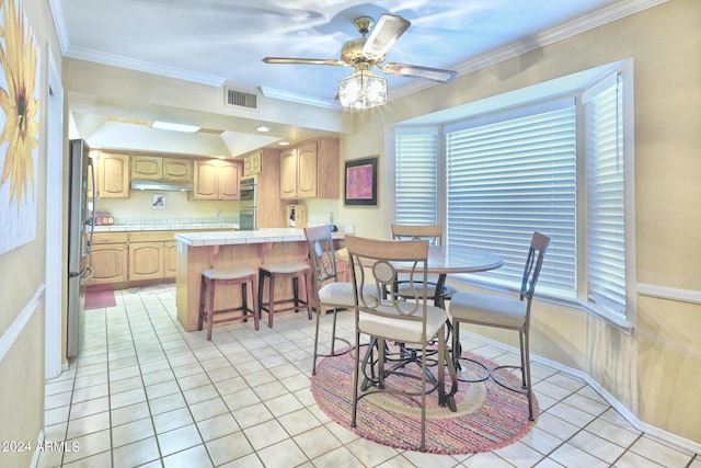 dining area with ceiling fan, light tile patterned flooring, and ornamental molding