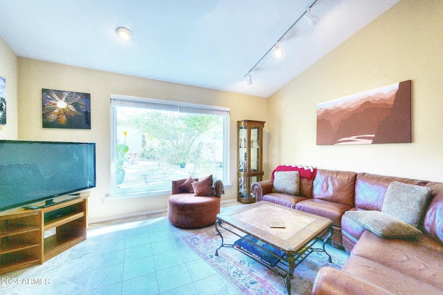 living room with vaulted ceiling, light tile patterned floors, and track lighting