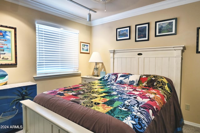 bedroom featuring ornamental molding, rail lighting, and carpet flooring