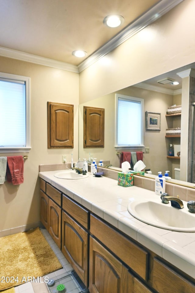 bathroom with vanity, ornamental molding, and tile patterned flooring