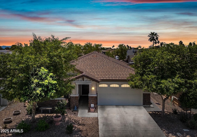 1344 N Claiborne, Mesa, AZ 85205 - view of front of home with concrete driveway, a garage, a tiled roof, and stone siding
