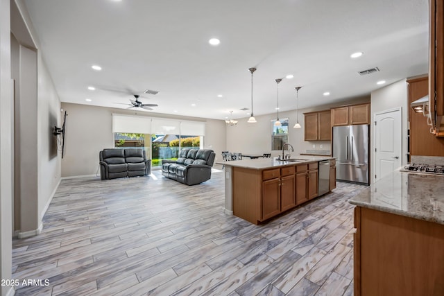 1344 N Claiborne, Mesa, AZ 85205 - kitchen with appliances with stainless steel finishes, open floor plan, brown cabinets, healthy amount of natural light, and recessed lighting