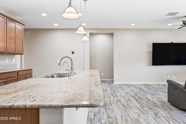 1344 N Claiborne, Mesa, AZ 85205 - kitchen with a sink, brown cabinetry, light stone countertops, recessed lighting, and open floor plan