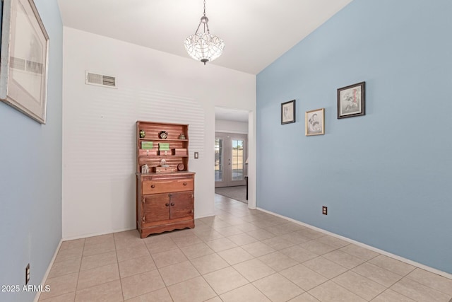 hall featuring french doors, light tile patterned floors, and a chandelier