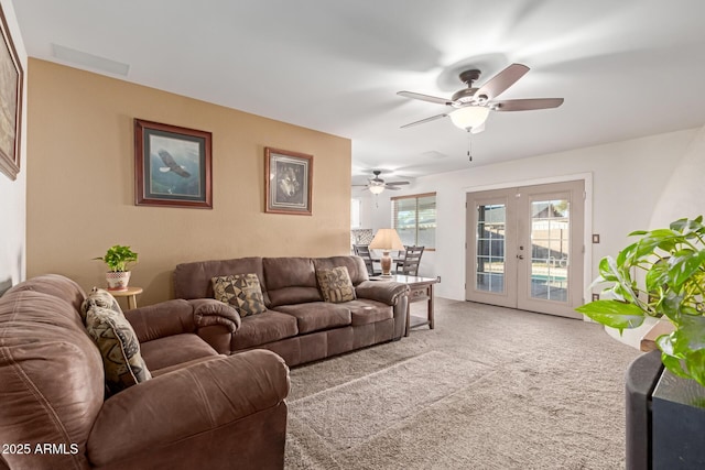 carpeted living room featuring french doors and ceiling fan