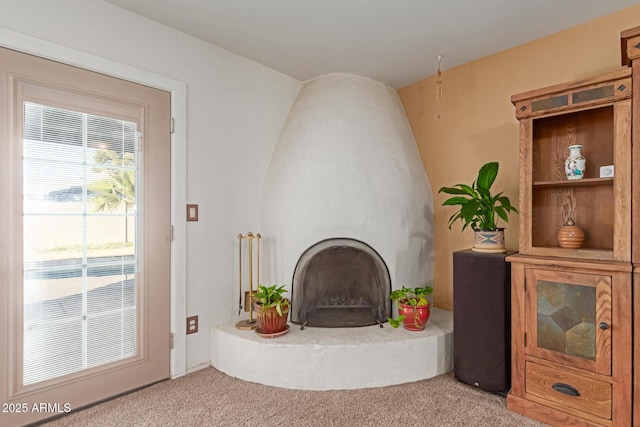 carpeted living room with a large fireplace