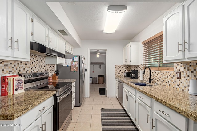 kitchen with sink, white cabinetry, light tile patterned floors, and appliances with stainless steel finishes