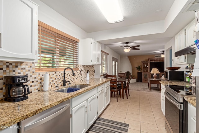 kitchen with appliances with stainless steel finishes, white cabinetry, light tile patterned floors, and sink