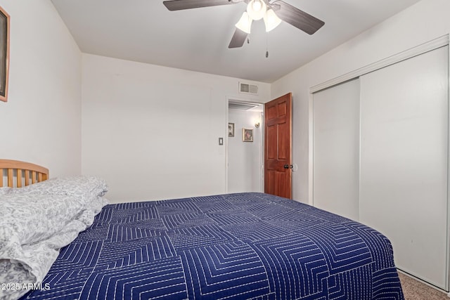 carpeted bedroom with ceiling fan and a closet