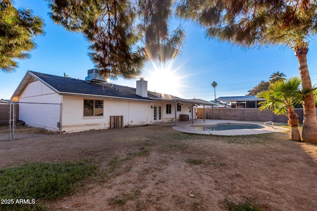 back of property featuring a patio area and a fenced in pool