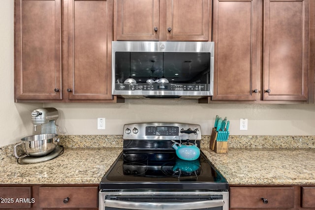 kitchen with light stone counters and appliances with stainless steel finishes