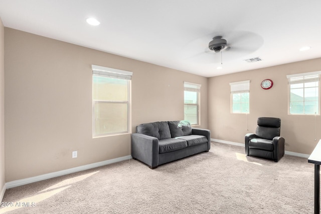 living room with visible vents, baseboards, and light colored carpet