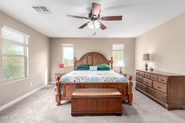 bedroom with multiple windows, baseboards, visible vents, and light carpet