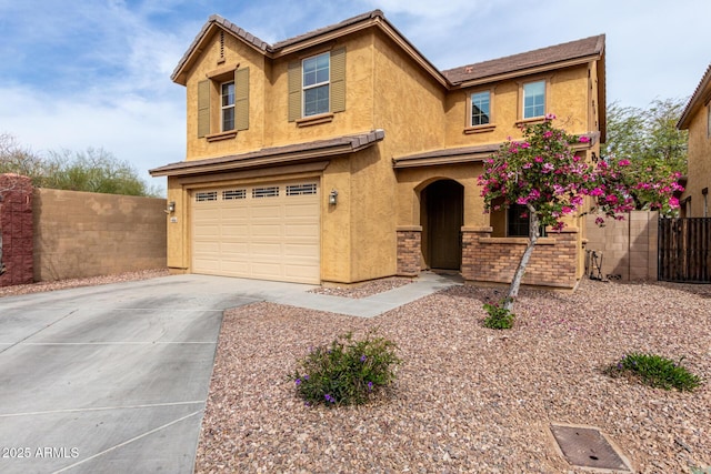 traditional-style house featuring a garage, concrete driveway, stucco siding, and fence