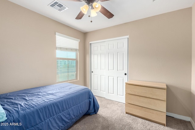 bedroom featuring visible vents, baseboards, light carpet, a closet, and a ceiling fan