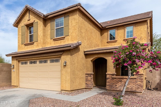 view of front of home with stucco siding, concrete driveway, and an attached garage