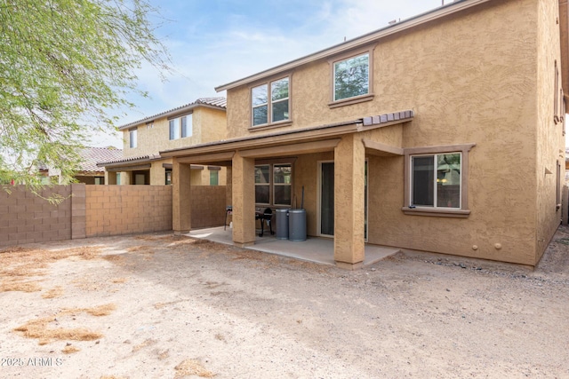 back of property featuring a patio, fence, and stucco siding