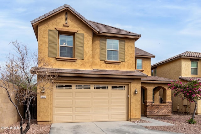 traditional home featuring stucco siding, driveway, and an attached garage