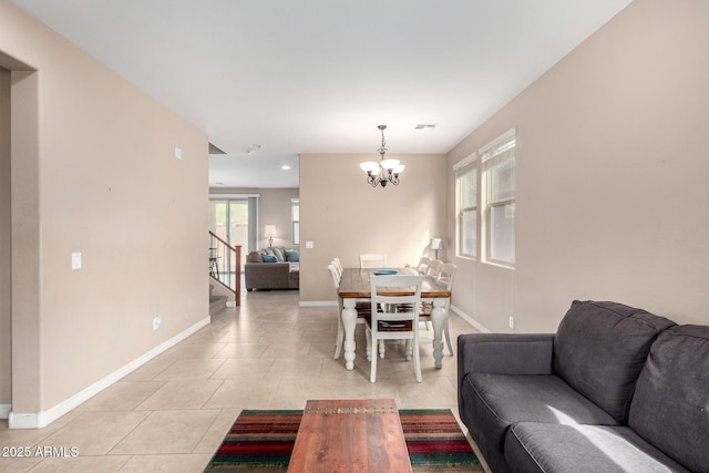 living area with stairway, light tile patterned floors, visible vents, baseboards, and a chandelier