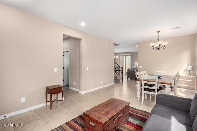 living area with visible vents, baseboards, a chandelier, stairway, and light tile patterned floors