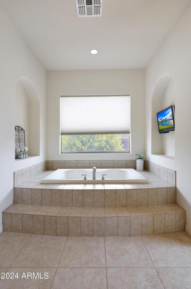 bathroom featuring tile patterned floors and a relaxing tiled tub