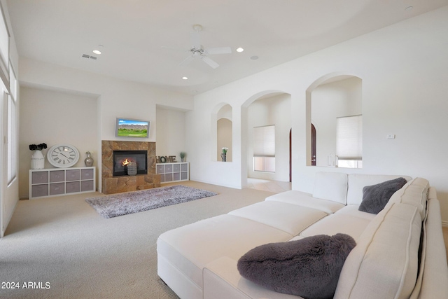 carpeted living room featuring ceiling fan and a tile fireplace