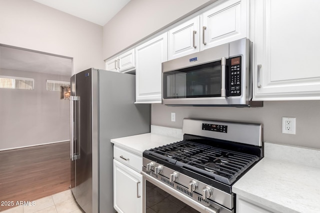 kitchen with white cabinetry, light tile patterned floors, and appliances with stainless steel finishes