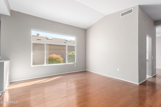 unfurnished living room with wood-type flooring and vaulted ceiling