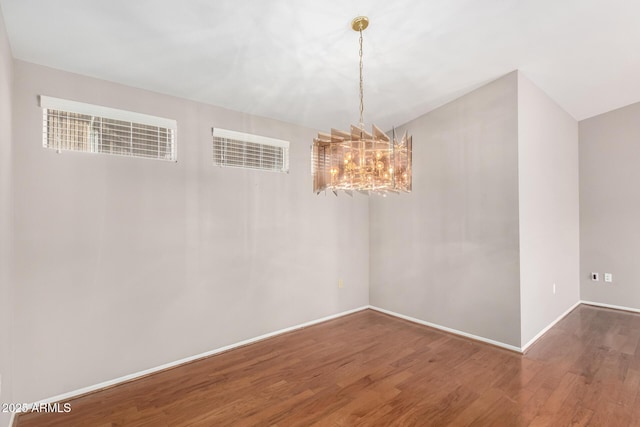 unfurnished dining area with an inviting chandelier and dark hardwood / wood-style flooring