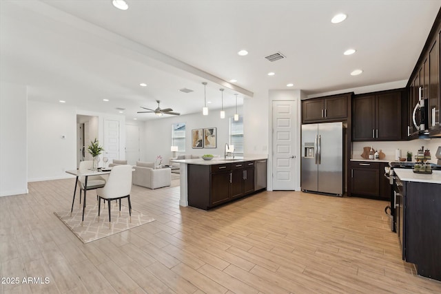 2187 W Burnside Trl, Phoenix, AZ 85085 - kitchen featuring stainless steel appliances, dark brown cabinetry, open floor plan, light countertops, and recessed lighting