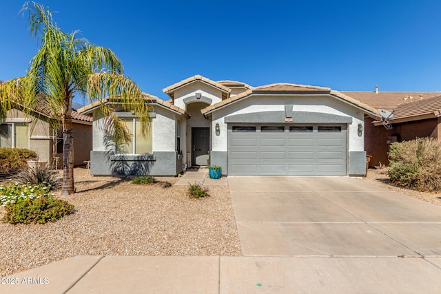 view of front of house with a tiled roof, an attached garage, driveway, and stucco siding