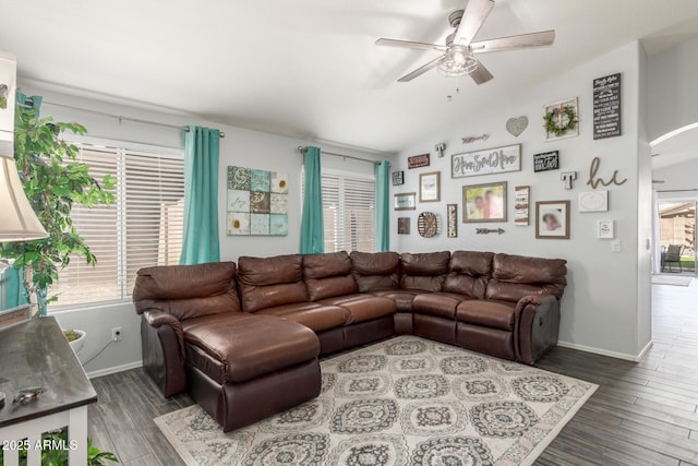 living room featuring arched walkways, vaulted ceiling, wood finished floors, and a healthy amount of sunlight