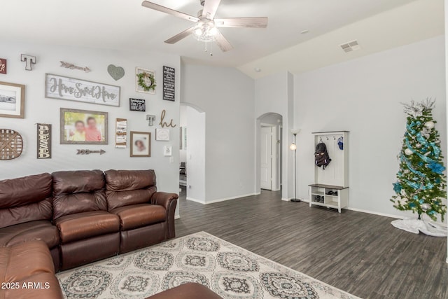 living room featuring visible vents, arched walkways, dark wood finished floors, a ceiling fan, and vaulted ceiling