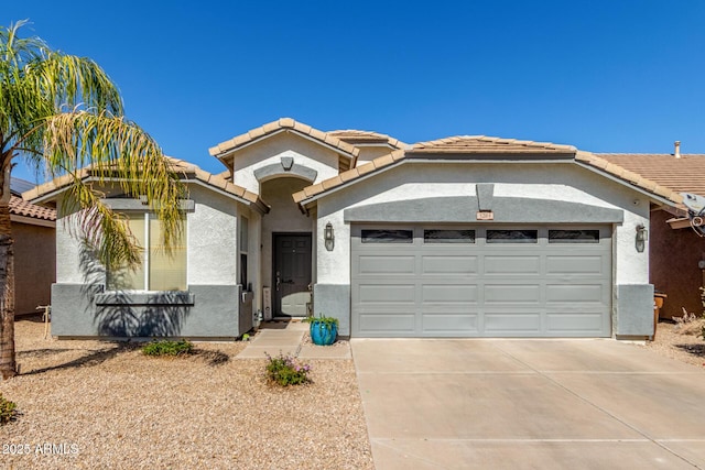 view of front facade with a garage, concrete driveway, a tile roof, and stucco siding